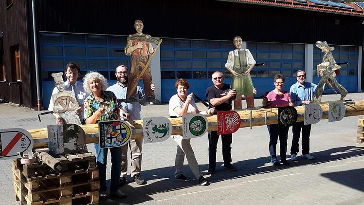 Symbolisch Hand an den neuen Bad Brückenauer Zunftbaum legten bei der Lagebesprechung im Bauhof (von links)  Dieter Sternecker, Helga Weißenberger, Markus Hehn, Bürgermeisterin Brigitte Meyerdierks, Karl Veit, Gabriele Friedrich und Wolfgang Povolny. Kurz vor dem Tanz in den Mai wird der bearbeitete und geschmückte Fichtenstamm am 30. April auf dem Markplatz aufgestellt. Rolf Pralle