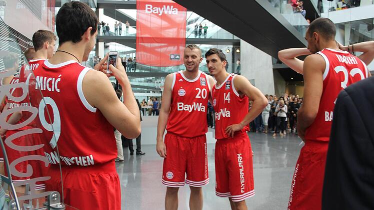 Die Bayern-Basketballer Dusko Savanovic (l.) und Nihad Djedovic ließen sich vor dem überdimensionalen neuen Heimtrikot fotografieren. Foto: Max Kaltenhäuser