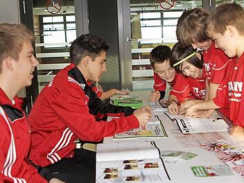 Mit Begeisterung schon beim Einkleben und Tauschen (von rechts) die E-Schüler Paul Brejcha, Elias Werner, Nico Rössner-Blazquez und Fabian Andritschke, während Philipp Eichhorn und Florian Koch (von links) für den Verkauf sorgten und Hilfestellung leisteten. Foto: Günther Geiling