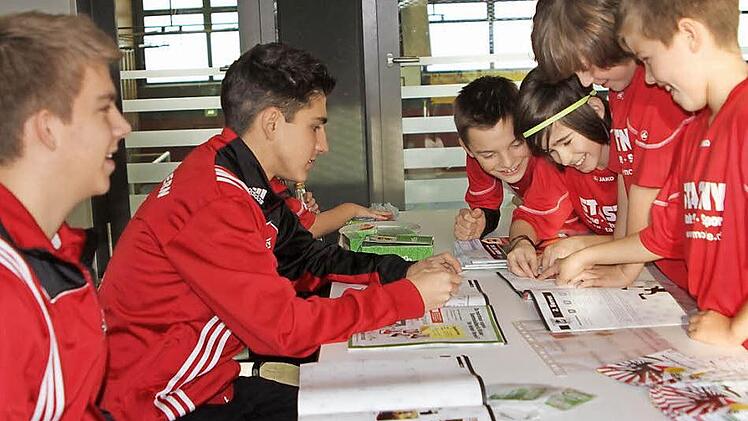 Mit Begeisterung schon beim Einkleben und Tauschen (von rechts) die E-Schüler Paul Brejcha, Elias Werner, Nico Rössner-Blazquez und Fabian Andritschke, während Philipp Eichhorn und Florian Koch (von links) für den Verkauf sorgten und Hilfestellung leisteten. Foto: Günther Geiling