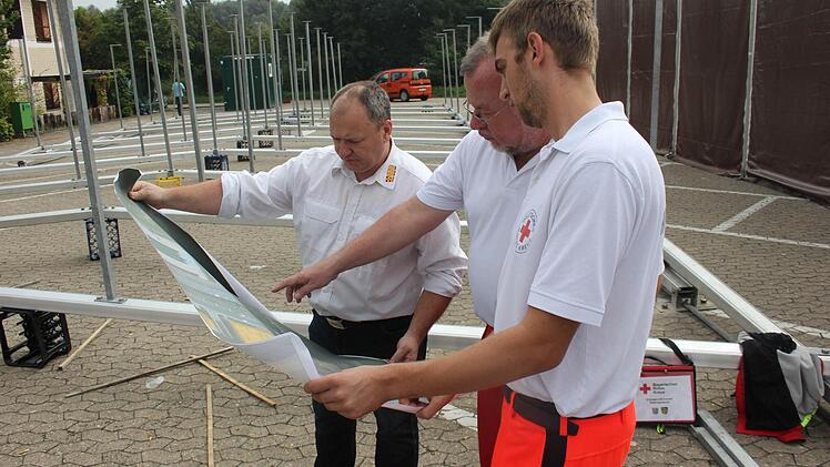 Jürgen Seiermann (ASB), Thomas Heideloff (BRK) und BRK-Mitarbeiter Julian Pertek besprechen strategische Lösungen.