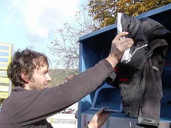 In Igensdorf wirft ein Mann einen Jacke in einen Altkleidercontainer.  Foto: Petra Malbrich