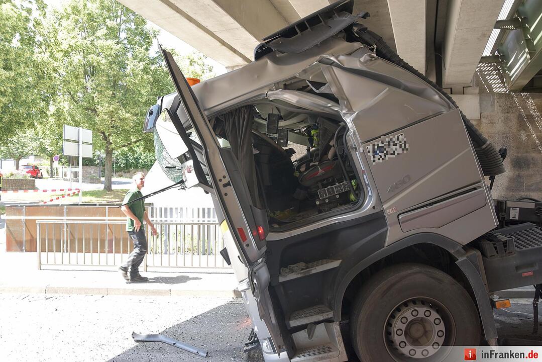 Lkw mit Kranaufbau fährt sich unter Brücke fest