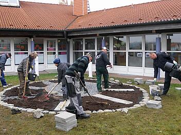 Zum Arbeitseinsatz  hatten sich Schülerväter und Kinder eingefunden, um gemeinsam die saisonalen Beete anzulegen, die künftig den Schulgarten bereichern sollen.  Foto: Jens Fertinger