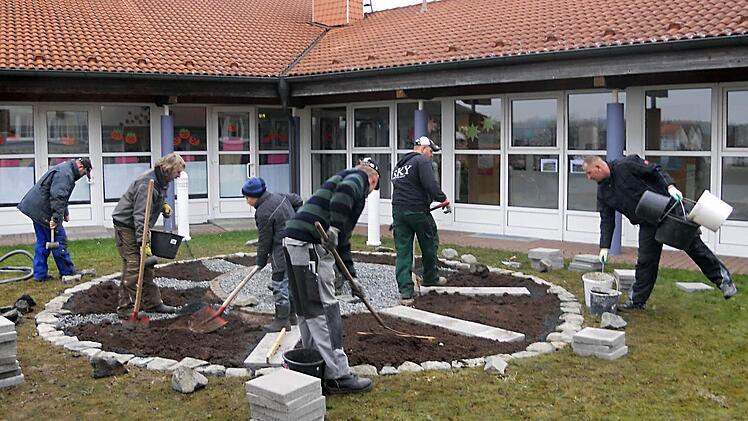 Zum Arbeitseinsatz  hatten sich Schülerväter und Kinder eingefunden, um gemeinsam die saisonalen Beete anzulegen, die künftig den Schulgarten bereichern sollen.  Foto: Jens Fertinger