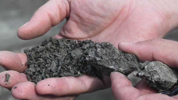 Durch fein zermahlene Teile hat sich der Split (links) unter dem Pflaster teilweise zu Klumpen (rechts) verdichtet. Darauf bewegen sich die Pflastersteine, wie ein Stein auf dem anderen und verschlechtern so den Zustand der Fahrbahn.  Fotos: Marco Meißner