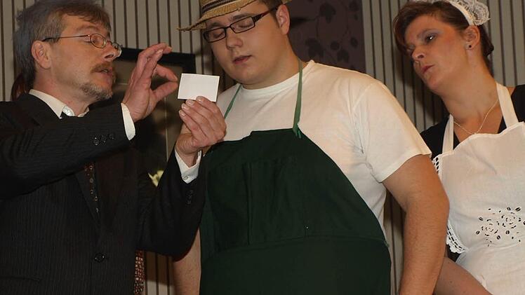 Marmeladenfabrikant Konstantin Kirschkern (Matthias Besler, links) möchte sein Image aufpolieren. Der Gärtner und spätere Butler (Markus Lutz) soll neue Visitenkarten in Druck geben; rechts dabei Köchin und Hausperle Verona (Anja Mützel).  Foto: Stefan Geiger