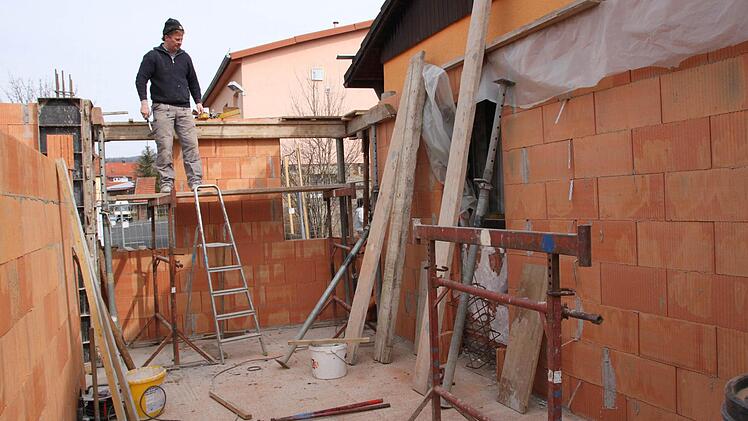 Bauarbeiter Achim Greul steht auf einem Gerüst.