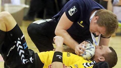 Florian Billek musste wieder kräftig einstecken. HSC-Betreuer Sebastian Weiß kühlte dem Coburger Rechtsaußen, dem seit dem Auswärtsspiel in Erlangen übertriebener Weise der Ruf eines "Schwalbenkönigs"  vorauseilt, nach einem Schlag ins Gesicht den Mund. Foto: Timo Geldner