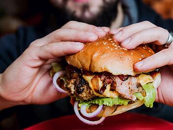 Darf man ohne schlechtes Gewissen in einen Burger beißen? Und wie teuer müsste er dafür sein? Ein Kommentar zur Diskussion um unsere Lebensmittelproduktion. Symbolfoto: romaset/Adobe Stock