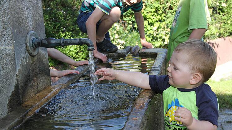 Erfrischung tut gut! Der einjährige Philipp an Fronleichnam am Quellbrunnen in Götzendorf Foto: Mathias Erlwein
