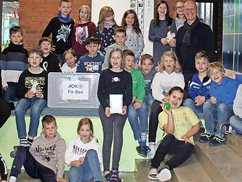Gemeinsam mit Schulleiterin Annette Marx nahm die 3. Klasse stellvertretend für alle Schülerinnen und Schüler die AOK-Fit-Box entgegen.