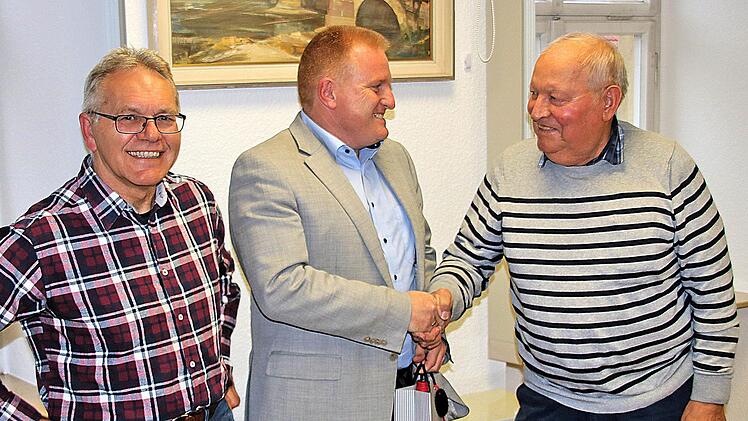 Bürgermeister Matthias Klement (Mitte) empfing im Alten Rathaus des  Ortsteils Poppenlauer Mitglieder der SPD-Arbeitsgemeinschaft 60plus und  informierte sie über die Gemeinde. Der Kreisvorsitzende Adolf Lieb (rechts)  bedankte sich mit einer Flasche Rotwein. Links der Seniorenbeauftragte der  Gemeinde, Winfried Streit. Foto: Dieter Britz