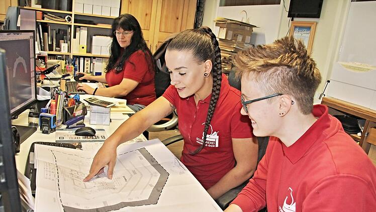 Die jungen Schreinerinnen, Azubi Svenja Hastedt und Gesellin Selina Lassmann (von rechts), besprechen im Büro der Firma einen Plan. Hinten Chefin Marianne Och. Foto: Helmut Will