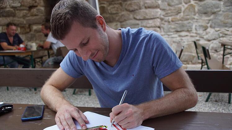 Auch das gehört zum Alltag eines Bierprinzen: Sebastian Gocker signiert Autogrammkarten.Sabine Weinbeer