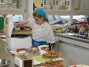 Jessica Grötzner backt die letzten Mini-Krapfen aus - gleich wird sie im Namen ihrer Klasse die Gäste begrüßen.  Foto: Sabine Weinbeer