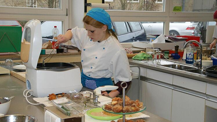 Jessica Grötzner backt die letzten Mini-Krapfen aus - gleich wird sie im Namen ihrer Klasse die Gäste begrüßen.  Foto: Sabine Weinbeer