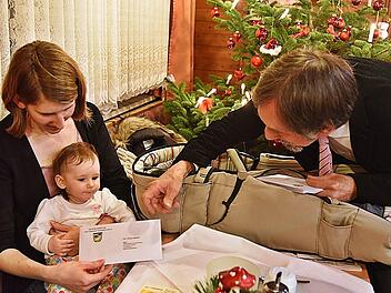 Bürgermeister Martin Rauscher übergibt das Extra-Kindergeld an Elina Hübner und ihre Mama Julia-Stefanie Hübner-Fischer. Foto: Gabi Arnold