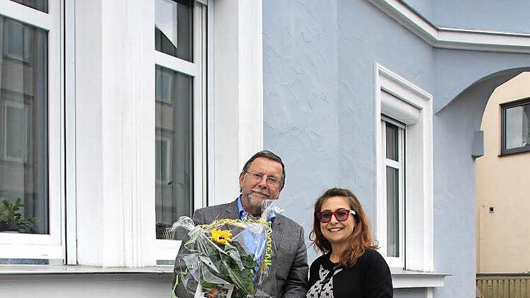 W&auml;hrend Hans-Heinrich Eidt Galia G&uuml;lcan Tunakan die Sanierungsmedaille &uuml;berreicht, schenkt ihm die dankbare Pilates-Trainerin eine Sonnenblume.