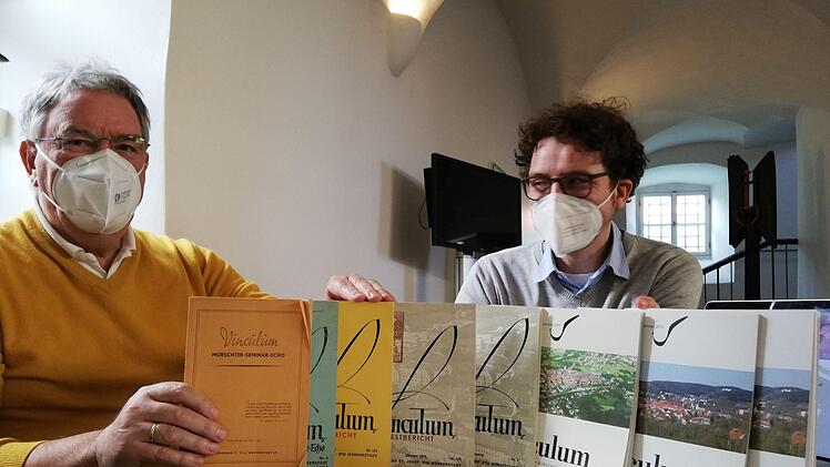 Paul Ziegler von den Studiengenossen (links) und Nicolas Zenzen zeigen eine Auswahl des Vinculum aus sieben Jahrzehnten. Die erste Ausgabe links im Bild war noch lediglich als kleiner Rundbrief gedacht.
