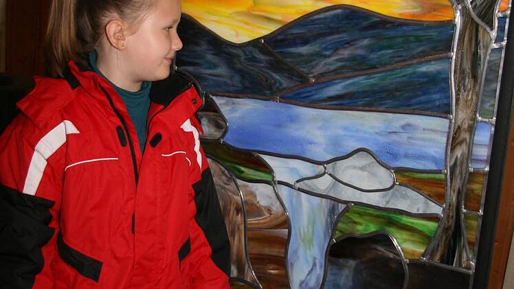 Ann-Sophie Wolf erkundet auf eigene Faust das Atelier. Und findet die Glasbilder, die mit Bleiverglasung im Tiffany-Stil zusammengefügt sind, einfach wunderbar. Foto: Sonja Adam