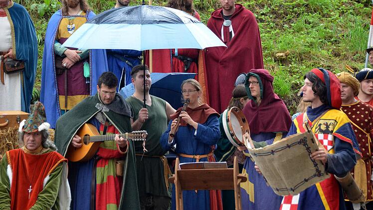 Der Begriff des Schirmherren bekam beim Burgfest eine andere Bedeutung. Die Musikinstrumente durften sich unter den Schutz der Schirme flüchten, aber die Menschen müssten die ganze Zeit über im Regen stehen - wie im Mittelalter auch. Foto: Peter Rauch
