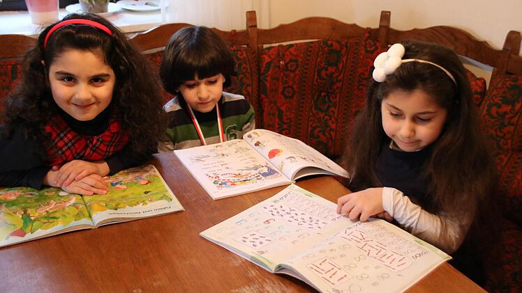 Sham, Laith und Judy (von links) bei den Hausaufgaben: Die syrischen Flüchtlinge besuchen seit einem halben Jahr die Grundschule. Foto: Ronald Heck