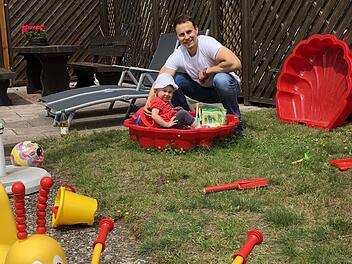 Der ganze Stolz heißt Clara. Während Georg Eckstein im heimischen Garten über das ganze Gesicht strahlt, schaut seine kleine Tochter doch eher skeptisch aus der roten Sandkastenschüssel. Wird de Papa wirklich Arzt in Neustadt...? Foto: Christoph Böger