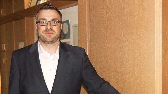 Der 30-jährige Verwaltungsmann Steffen Kropp will Bürgermeister von Rentweinsdorf werden. Hier steht der Kandidat an der Tür des Bürgermeisterzimmers, in das er nach der Wahl Einzug halten will. Foto: Günther Geiling