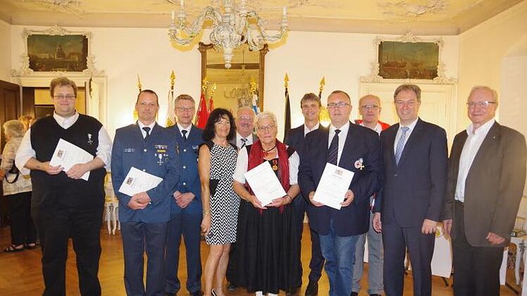 Patrick Schnepff (l.), Gerhard Graf (3.  v. l.) und Andreas Kristek (4. v. r.) erhielten Dienstauszeichnungen f&uuml;r BRK und THW, w&auml;hrend Sigrid Stahlberger (6. v. r.) mit der Verdienstmedaille des Verdienstordens der Bundesrepublik  ausgezeichnet wurde. Das Bild zeigt sie mit den Verbandsvertretern sowie Landrat L&ouml;ffler.