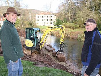 Robert Hildmann (links), der Leiter der Schlossgärtnerei, und Norbert Englert vom Wasserwirtschaftsamt Bad Kissingen betreuen die Bauarbeiten im Schlosspark. Im Hintergrund setzt Norbert Romeis mit dem Bagger Steine ans Sinnufer. Fotos: Ralf Ruppert