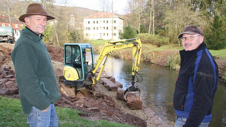 Robert Hildmann (links), der Leiter der Schlossgärtnerei, und Norbert Englert vom Wasserwirtschaftsamt Bad Kissingen betreuen die Bauarbeiten im Schlosspark. Im Hintergrund setzt Norbert Romeis mit dem Bagger Steine ans Sinnufer. Fotos: Ralf Ruppert