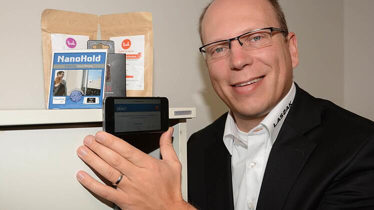 Pfiffiger Helfer: Der Nano-Hold ist ein Nanotechnologie-Kleber, mit dem Smartphones und Tablets an jeder beliebigen glatten Oberfläche befestigt werden können. Unternehmensgründer Tim Barkow hat die Klebefolie auch an der Rückseite seines eigenen Handys angebracht. Damit kann man nebenbei auch sehr komfortabel Selfies fotografieren und hat dabei die Hände frei. Foto: Dagmar Besand