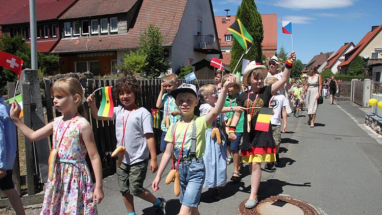"Fremde Länder" lautet das Motto des Wiesenfestes. Freudig schwenken die Kinder aus der ersten Klasse ihre Flaggen. Foto: Stephan Stöckel