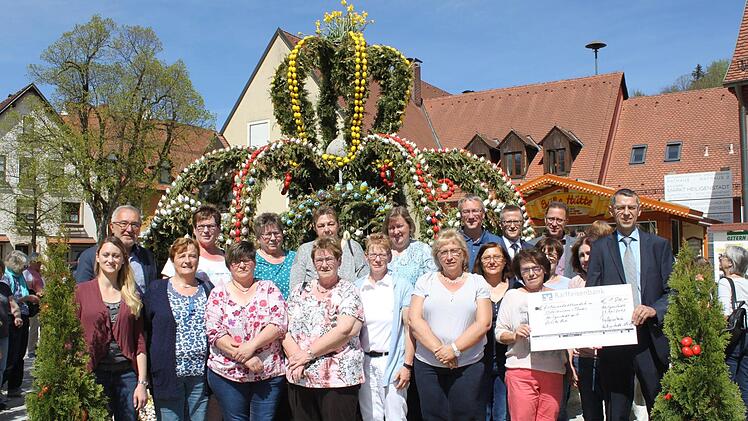 Bürgermeister Helmut Krämer (hinten links) lud die Osterbrunnen-Helfer zum Kaffee-Trinken ein, Reinhard Dölfel von der örtlichen Raiffeisenbank brachte den Spendenscheck mit, durch den die Auslagen von rund 1800 Euro gedeckt werden. Foto: Carmen Schwind
