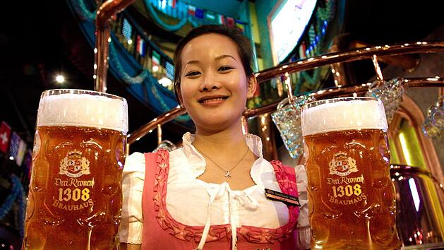 Weibliche Bedienungen tragen in den "Drei-Kronen-Brauhauses" in China Dirndl, ihre männlichen Kollegen Lederhose. Frankonia ist den Asiaten kein Begriff, Bavaria sehr wohl. Das Bier im Maß ist süßer als das fränkische Original, aber von deutschen Brauern in China nach dem Reinheitsgebot und anhand des Originalrezepts eingebraut.  Fotos: Drei Kronen 1308, Schanz
