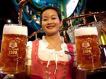 Weibliche Bedienungen tragen in den "Drei-Kronen-Brauhauses" in China Dirndl, ihre männlichen Kollegen Lederhose. Frankonia ist den Asiaten kein Begriff, Bavaria sehr wohl. Das Bier im Maß ist süßer als das fränkische Original, aber von deutschen Brauern in China nach dem Reinheitsgebot und anhand des Originalrezepts eingebraut.  Fotos: Drei Kronen 1308, Schanz