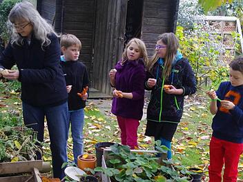 Die Leiterin der AG Schulgarten, Monika Graß, schält für Krista, Lea, Lisa und Danny (von links) leckere Topinambur.