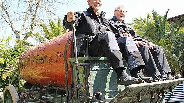Jürgen Sand (links) und Helfer Rudolf Bamberg haben sich auf den Kutschbock des historischen Wasserwagens geschwungen.  Fotos: Benedikt Borst