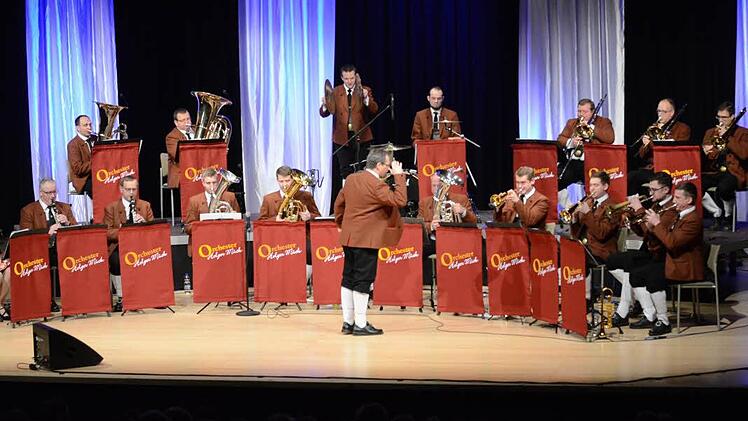 Orchestergründer und -leiter, Holger Mück, kniet sich förmlich mit Leidenschaft in seine Dirigentenrolle und spricht mit seinen Musikern während des Spielens. Foto: Karl-Heinz Hofmann
