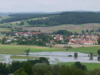 Nasse Sache: Der Itzgrund - hier vom "Oberen Berg" bei den beiden Windrädern aus mit Blickrichtung Lahm - ist seit den Regenfällen von Dienstag/Mittwoch eine Seenlandschaft. Foto: Berthold Köhler