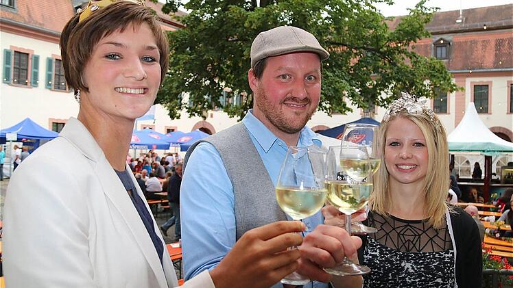 Umrahmt von den lieblichen Weinhoheiten Christin Ungemach (links), der Fränkischen Weinkönigin, und Antonia Müller (rechts), der ansässigen Weinprinzessin, begrüßte Kellermeister Matthias Büttner die vielen Gäste im Schlosshof. Fotos: Gerd Schaar