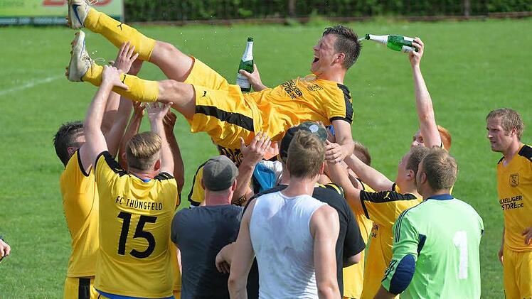 SG Ampferbach/Steinsdorf - FC Thüngfeld: Erst nach fün Minuten Nachspielzeit fiel die ganze Anspannung bei den Gästen ab. Spielertrainer und Meistermacher Michael Blankenbühler wurde mit Sektduschen von seiner Mannschaft gefeiert. Fotos: Picturedreams