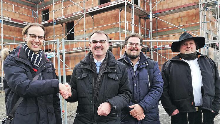 :Bürgermeister Harald Hofmann (2. von links) bedankt sich bei Baurat Matthias Noll (links) von der Regierung von Unterfranken, für die Bauförderung; daneben stehen der Nüdlinger Architekt Matthias Kleinhenz (mk bauberatung; 2. von rechts) und Zimmerermeister Mario Schneider (S + S Holzbau, Münnerstadt). Foto: Sigismund von Dobschütz