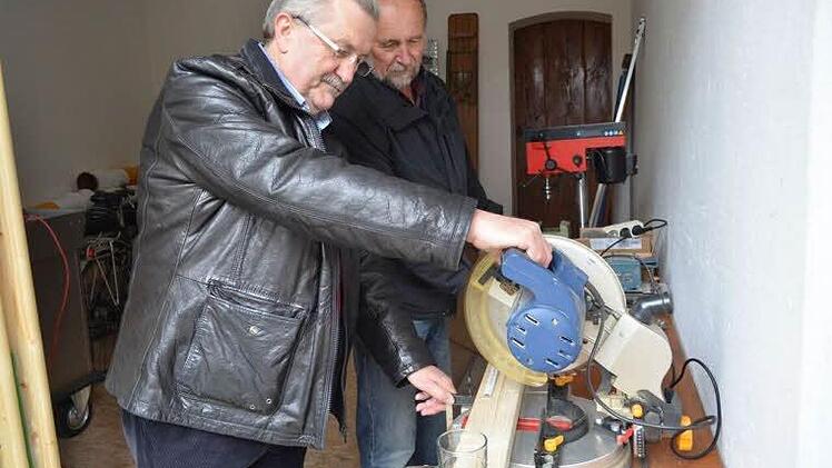 Während Gerhard Wirkner (r.) das Brett ausmisst, testet Georg Römer schon einmal die Säge.  Foto: Larissa Händel