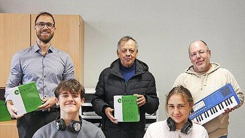 Hans Georg Ke&szlig;ler (hinten Mitte) von der Stiftung &uuml;bergibt die Spende an die Musikfachschaft des Jack-Steinberger-Gymnasiums.