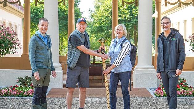 Monika L&ouml;sser &uuml;bergab als Vertreterin der Stadt Meiningen den Rh&ouml;ner Staffelstab an Bad Bocklets B&uuml;rgermeister Andreas Sandwall. Kurdirektor Thomas Beck (links) und Andreas Vogel von der Rh&ouml;n GmbH (rechts) waren mit von der Partie. Foto: Alexander Martin