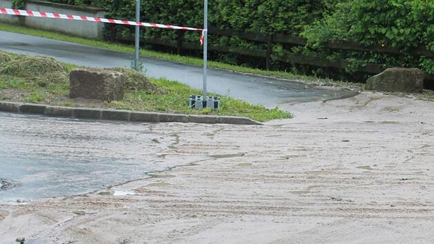 Die Schlammlawine machte auch vor dem Radweg nicht Halt machte, hier in der Siedlungsstra&szlig;e. Foto: Schreiber