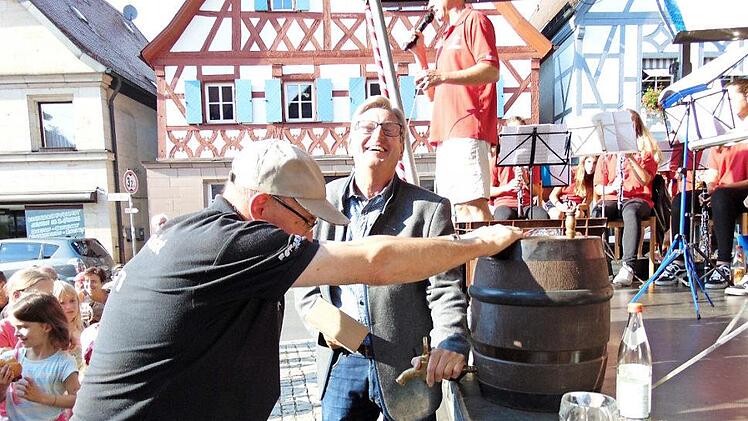 Bürgermeister Heinz Richter schwingt den Holzhammer zum Bieranstich - ein Helfer hält das Fass.  Fotos:  Petra Malbrich