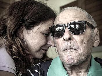 Alexandra lehnt ihren Kopf an den ihres Vaters Karl. Seine Demenz bereitet ihr oft Kummer. Aber sie ist sicher, dass Karl sich wohlfühlt.  Foto: Diana Fuchs